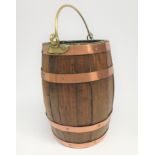 An ash copper bound bucket, 19th century, of coopered construction with brass swing handle,