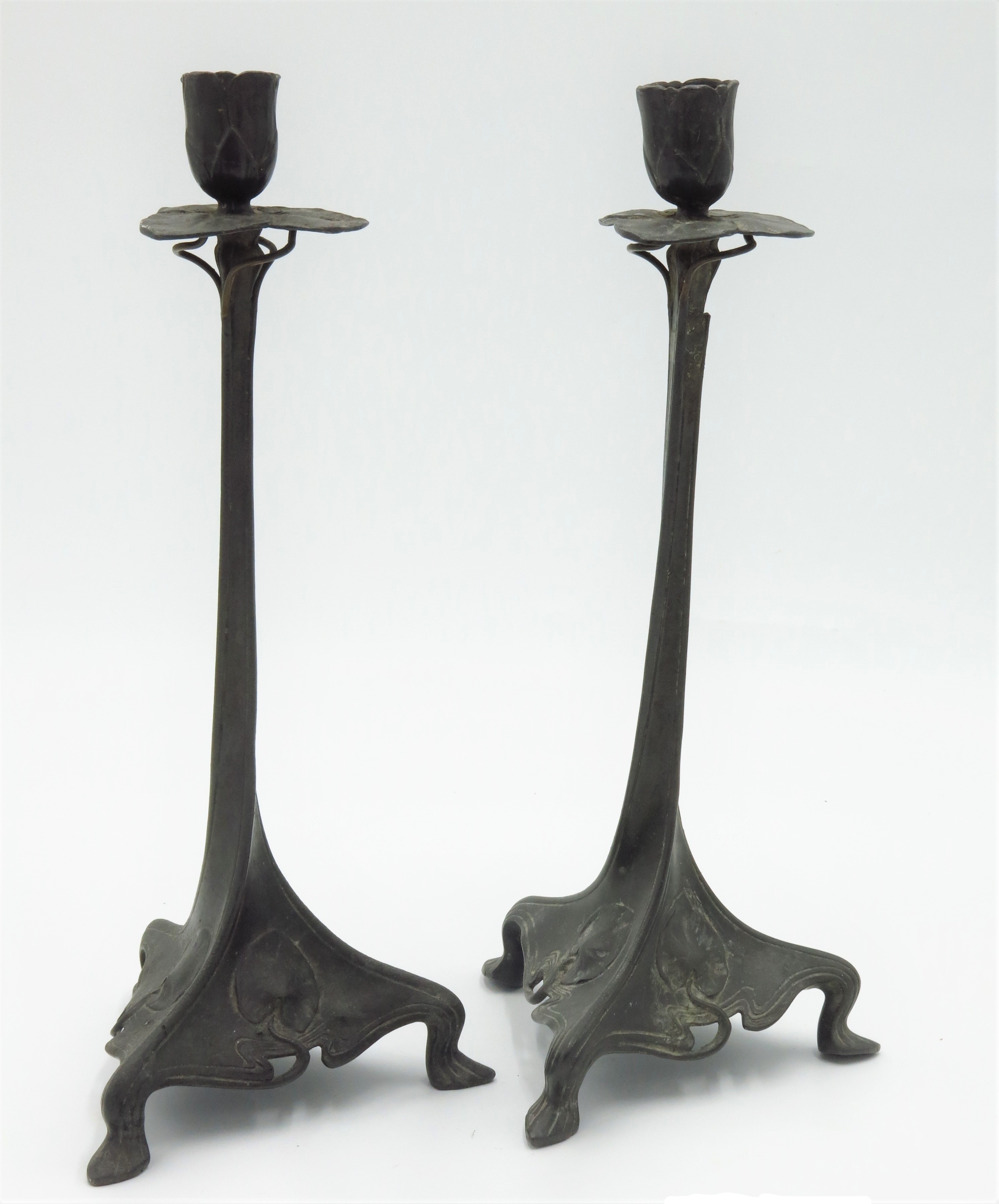 A pair of continental Art Nouveau pewter candlesticks, circa 1900, with leafy nozzles, twisted,