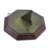 A brass octagonal sun dial, with indistinct inscription and dated 1784, on a later mahogany plinth,
