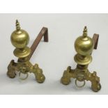 A pair of brass and steel andirons in 17th century style with turned finials above lion mask ring