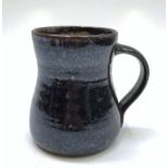 A Michael Leach Yelland pottery mug, of waisted form, brown glazed, height 13cm.