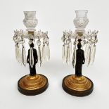 A pair of Regency bronze and gilt figural lustre candlesticks, with cut glass sconces,
