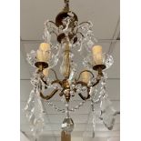 A cut glass four branch chandelier, with gilt arms and flattened hanging drops, height 35cm.