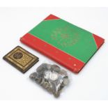 A small collection of assorted coins, a stamp album and a small book.