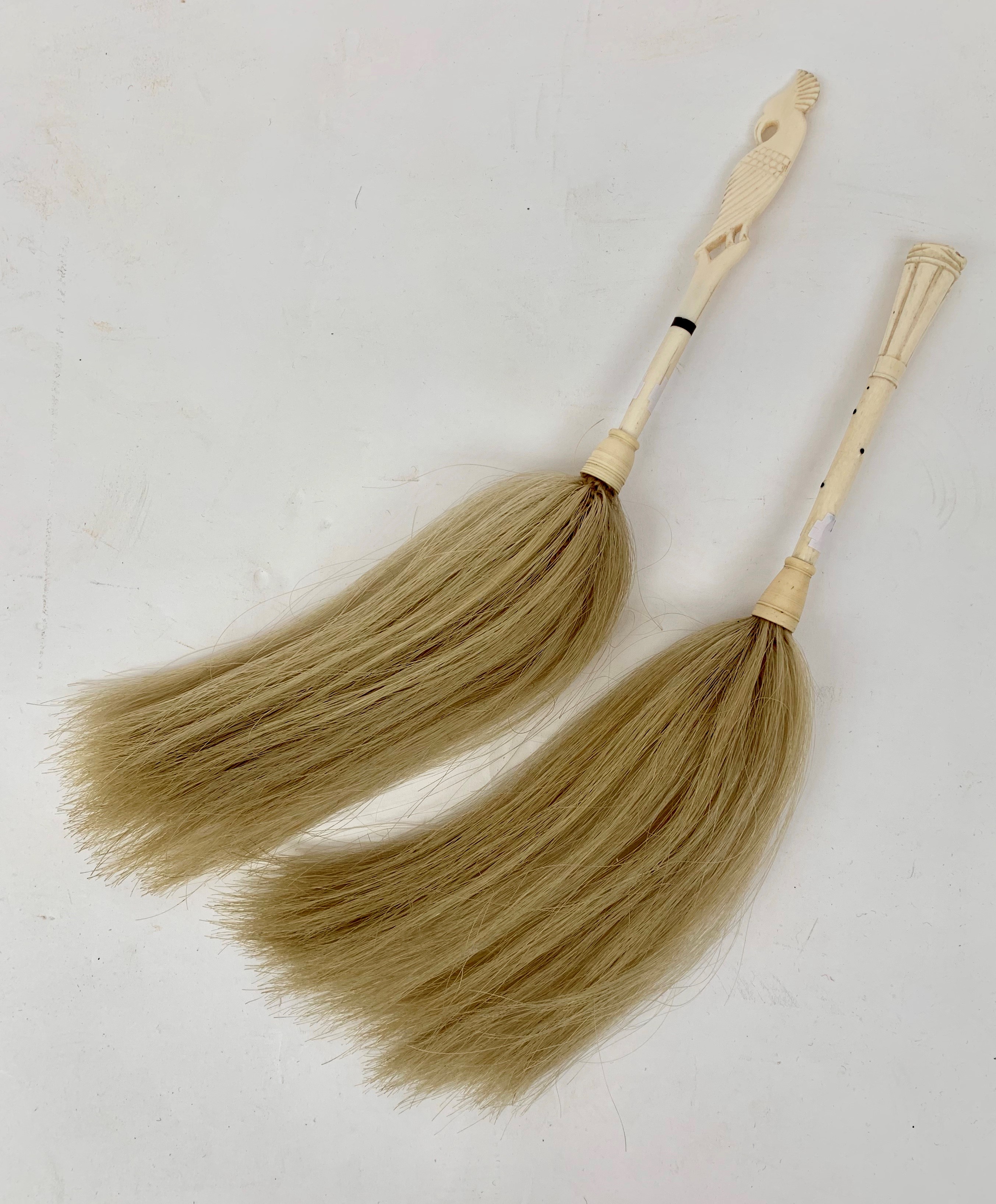 Two carved bone and horsehair fly whisks, the largest handle 18cm.