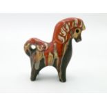 An Eric Leaper pottery horse, in typical red, orange and brown glazes, height 14cm, width 14cm.