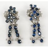 A pair of 18ct white gold sapphire and diamond earrings each with an asymmetric cluster from which