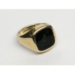 A 9ct gold signet ring set with a crested black onyx intaglio carved with a hawk holding a trident.