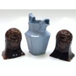 A pair of Victorian treacle glazed pottery window stops, each moulded with a bearded mask,