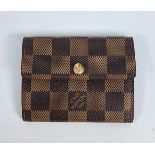 A Louis Vuitton chequer bi fold purse with stud fastener,