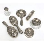 A good modern seven piece silver mounted dressing table set repousse decorated with birds and