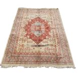 A Heriz design carpet, the ivory field with a large madder medallion, with hooked guls,