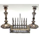 A pair of late Sheffield plated candlesticks with applied filled silver scroll work and a Victorian