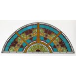 A demi-lune leaded glass panel, with stained and coloured panels, height 57cm, width 126cm.