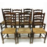 Seven ladderback dining chairs and a similar armchair.