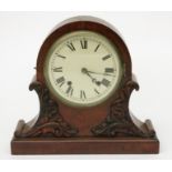 A Victorian walnut cased mantel clock, the arched case with leaf carved mouldings,