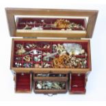 Costume jewellery in a jewel chest in a wooden jewellery box.