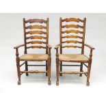 A pair of ladderback rush seated armchairs, early 20th century, height 111cm, width 63cm.