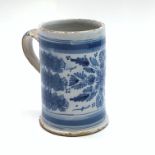 A Continental tin glaze blue and white mug, 18th century, sponged and painted with foliage,