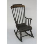 A Victorian black painted rocking chair, the top rail with gilt foliate decoration,