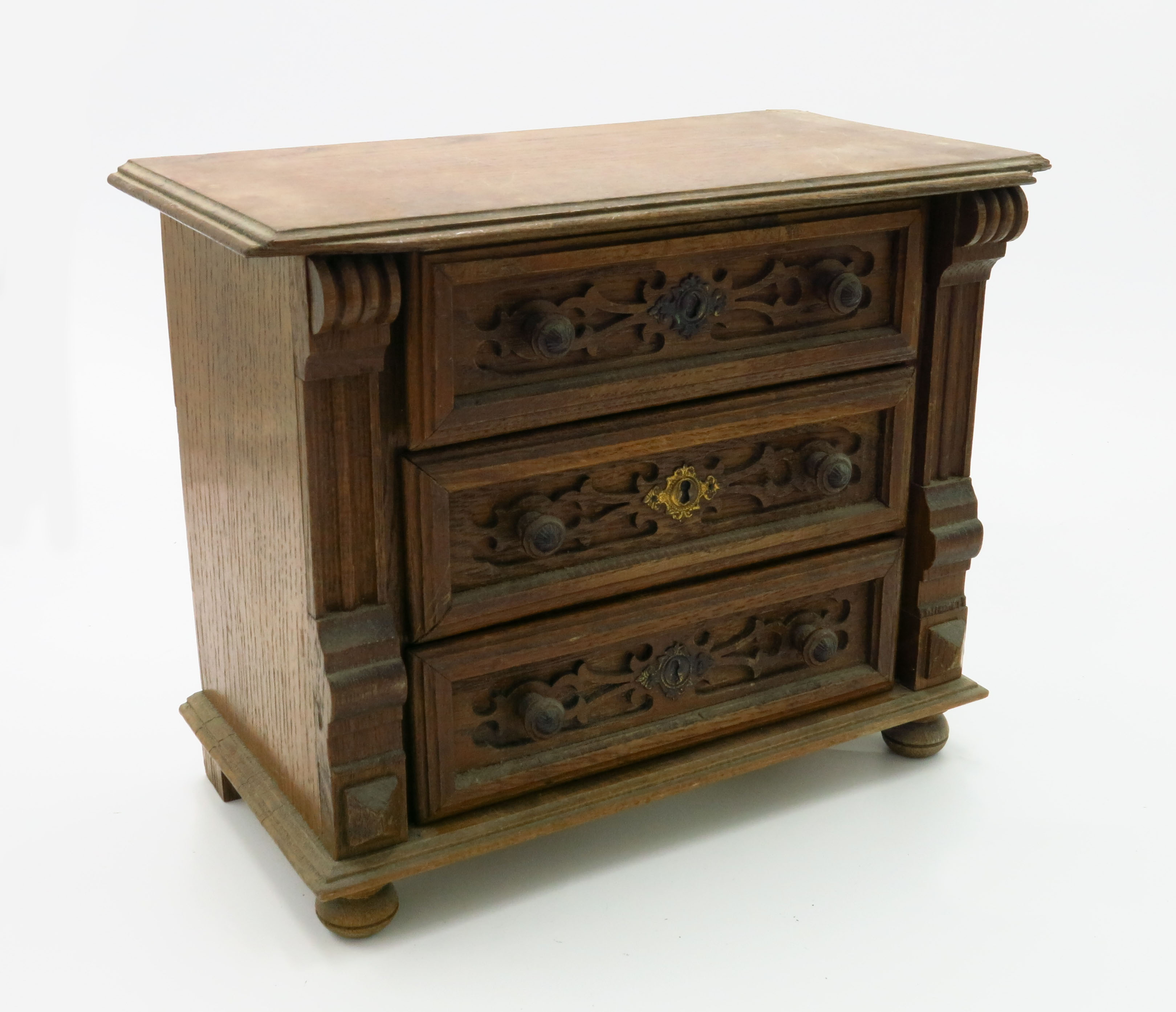 A miniature oak chest of drawers, early 20th century, with three long drawers, height 24.