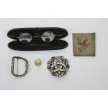 Two buckles, a papier mache spectacle case with gilt spectacles and two other pieces.