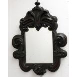 An unusual late Victorian carved mahogany wall mirror, with a leaf decorated frame, height 78cm,