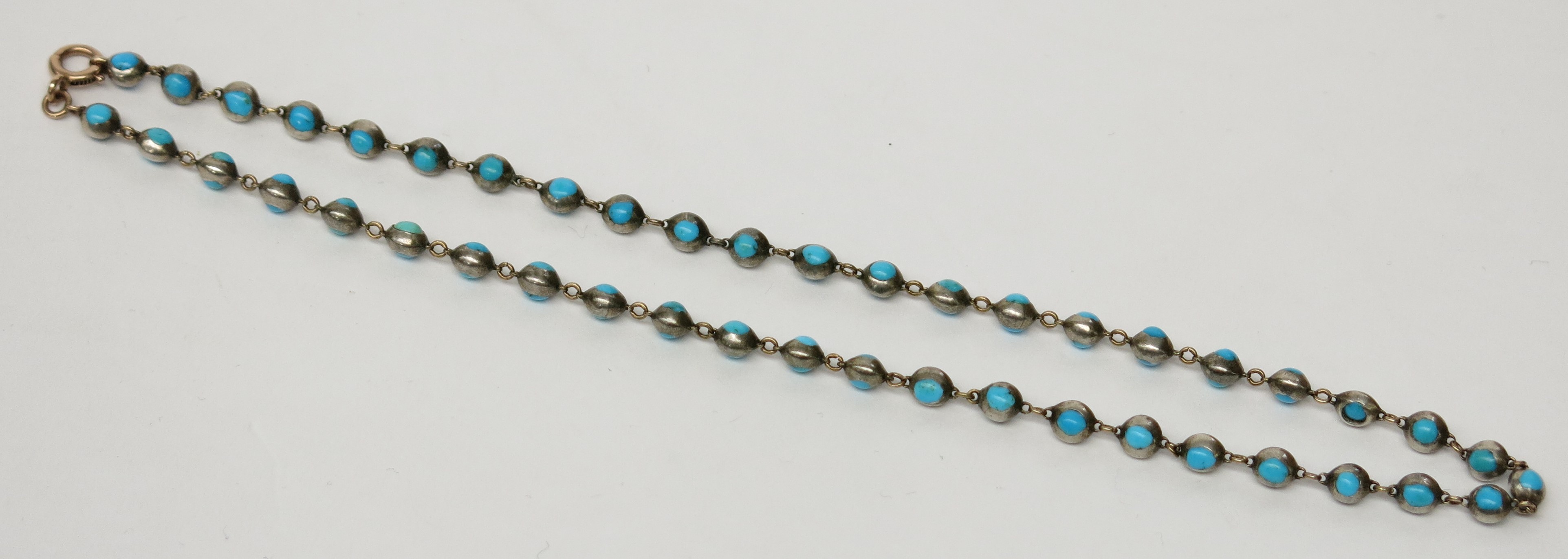 An antique necklace with turquoise set beads joined by gold links.