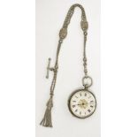 A small engraved silver cased key wind pocket watch on silver chain with multi strands and chased