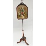 A pair of Victorian mahogany polescreens, each with a woolwork panel decorated with figures,