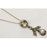 An impressive diamond pendant from a yellow old cut stone of approximately 1ct hangs a stylised