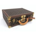 A Louis Vuitton monogram briefcase, trimmed with brown motif studded leather and brass mounts,