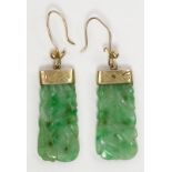 A pair of gold mounted carved jade earrings.