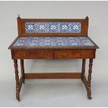An Arts and Crafts oak washstand, the back and top with rows of blue and white pottery tiles,
