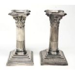 A pair of Corinthian column silver plated candlesticks with detachable nozzles,