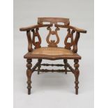 A Victorian oak captain's armchair, with a rattan seat and turned legs, height 84cm, width 70cm.