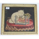 A Victorian woolwork picture of a cat and a caged canary on a table,