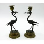 A pair of brass and bronze Regency style candlesticks, 19th century, on circular bases,