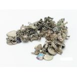 A silver charm bracelet 137g this includes some lower purity charms and coins.