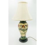 A Moorcroft Pottery table lamp, of baluster form, tube lined and painted with a floral design,