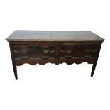 An oak dresser base, 18th century, with two drawers above a shaped apron, on square tapering legs,