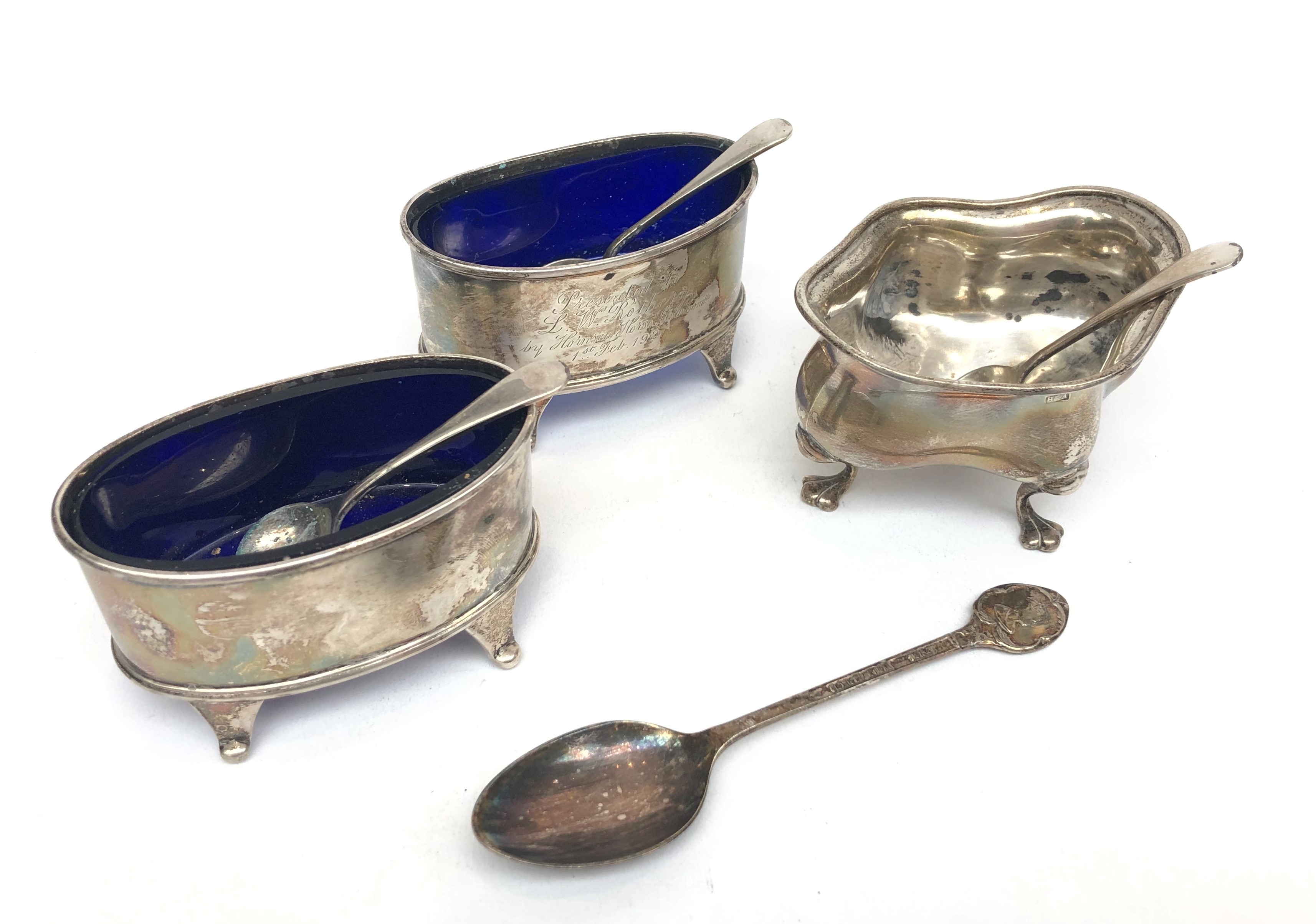 A pair of oval Atkin Brothers silver open salts with blue glass liners and matching salt spoons,