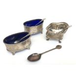A pair of oval Atkin Brothers silver open salts with blue glass liners and matching salt spoons,