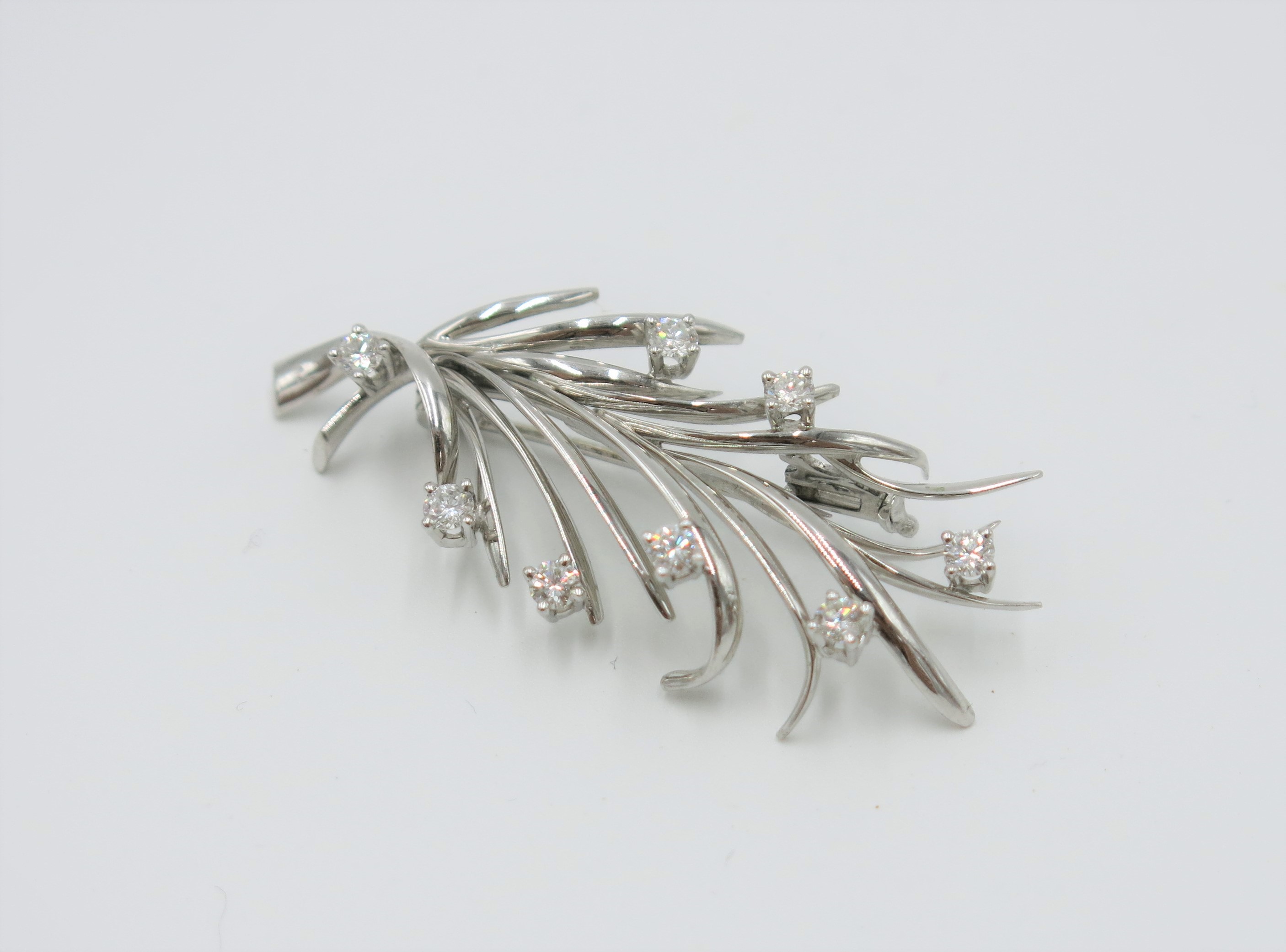 An 18ct white gold spray brooch set with eight diamonds.