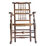 An elm spindle back rush seated armchair, 20th century, height 104cm, width 59cm.