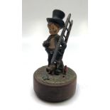 A Black Forest music box, circa 1900, modelled as a chimney sweep, height 17.5cm.