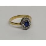 A sapphire and diamond oval cluster ring set in 18ct gold.