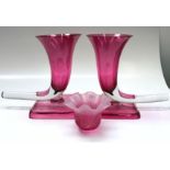 A pair of cranberry glass cornucopia vases, late 19th century, each on a square base, height 29cm,