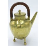 A W A S Benson brass teapot, of ovoid shape with overhead wooden handle and raised upon three legs,