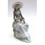 A Lladro figure of a lady, seated with a puppy on her lap, height 34cm.